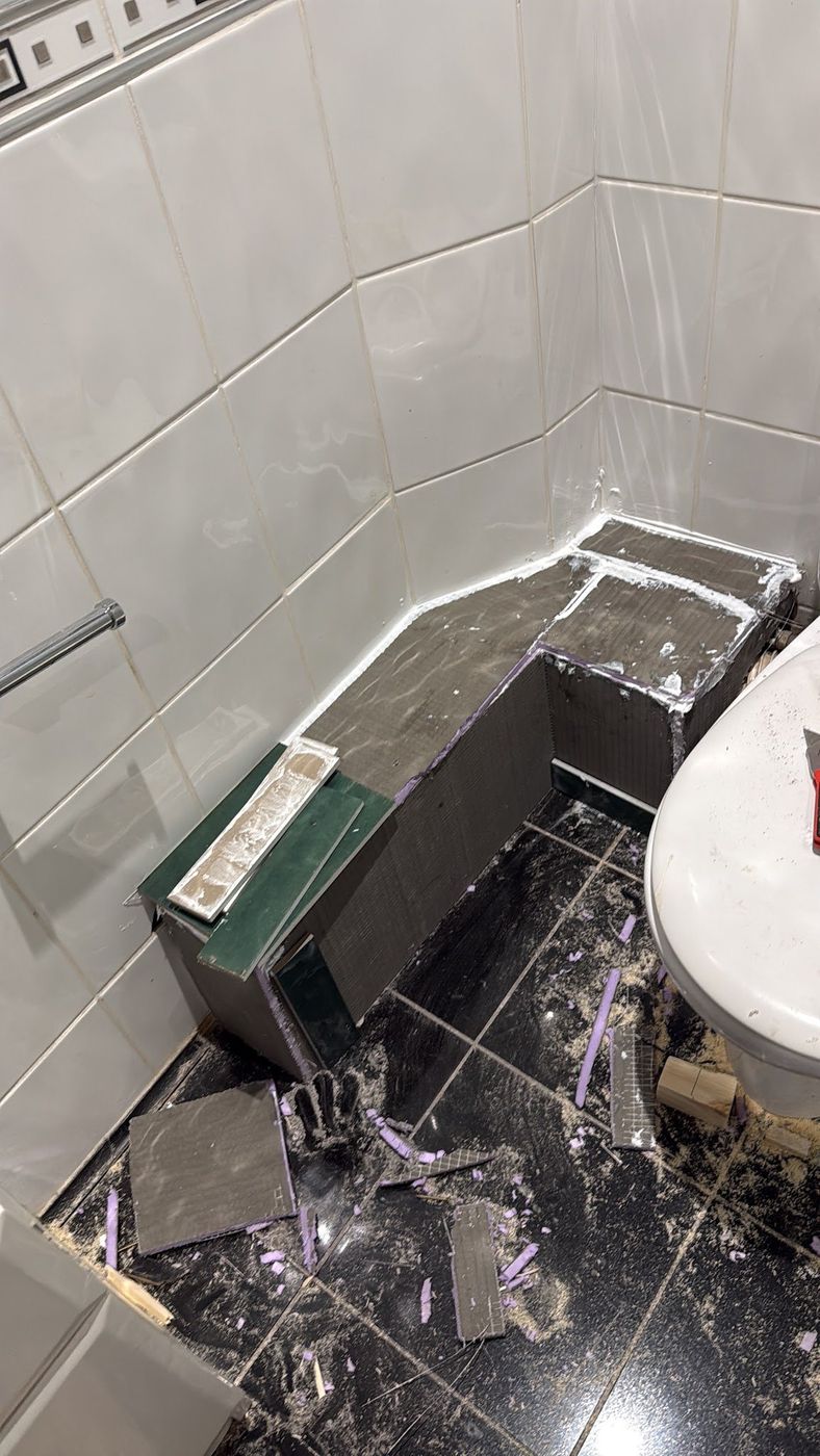 Bath panel being tiled and sealed in a bathroom