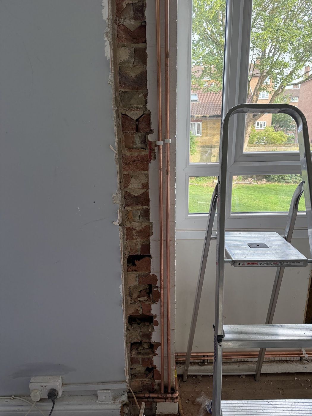 Wall chased out for copper pipework beside a window